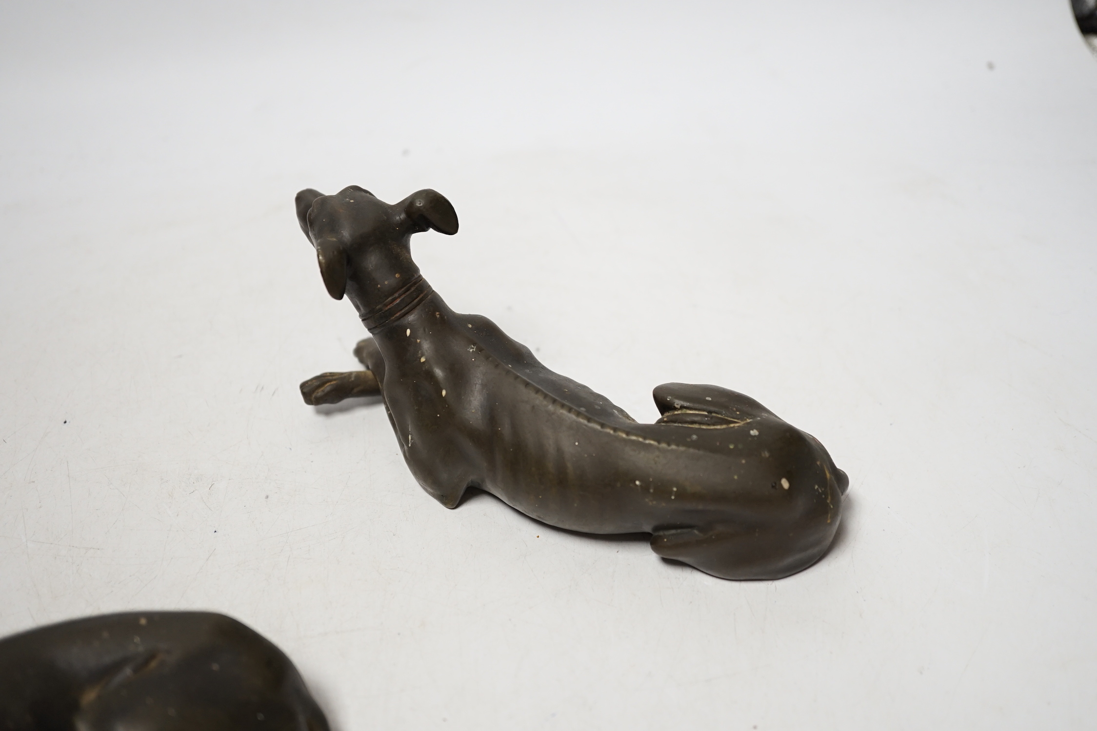 Three late 19th century bronze models of recumbent greyhounds, 17cm